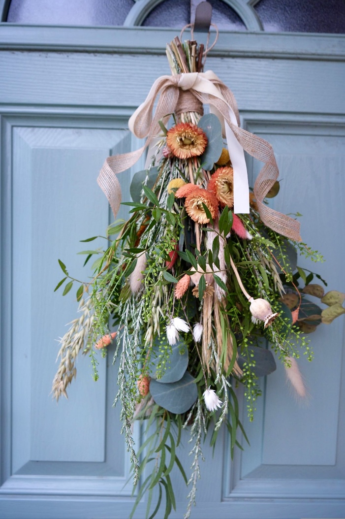 Luxury swag combining eucalyptus and strawflower with ribbon, in a cascading design