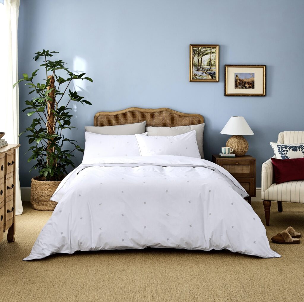 Calm blue bedroom with powder-blue walls and Dip & Doze ‘Amongst the Stars’ organic cotton bedding.