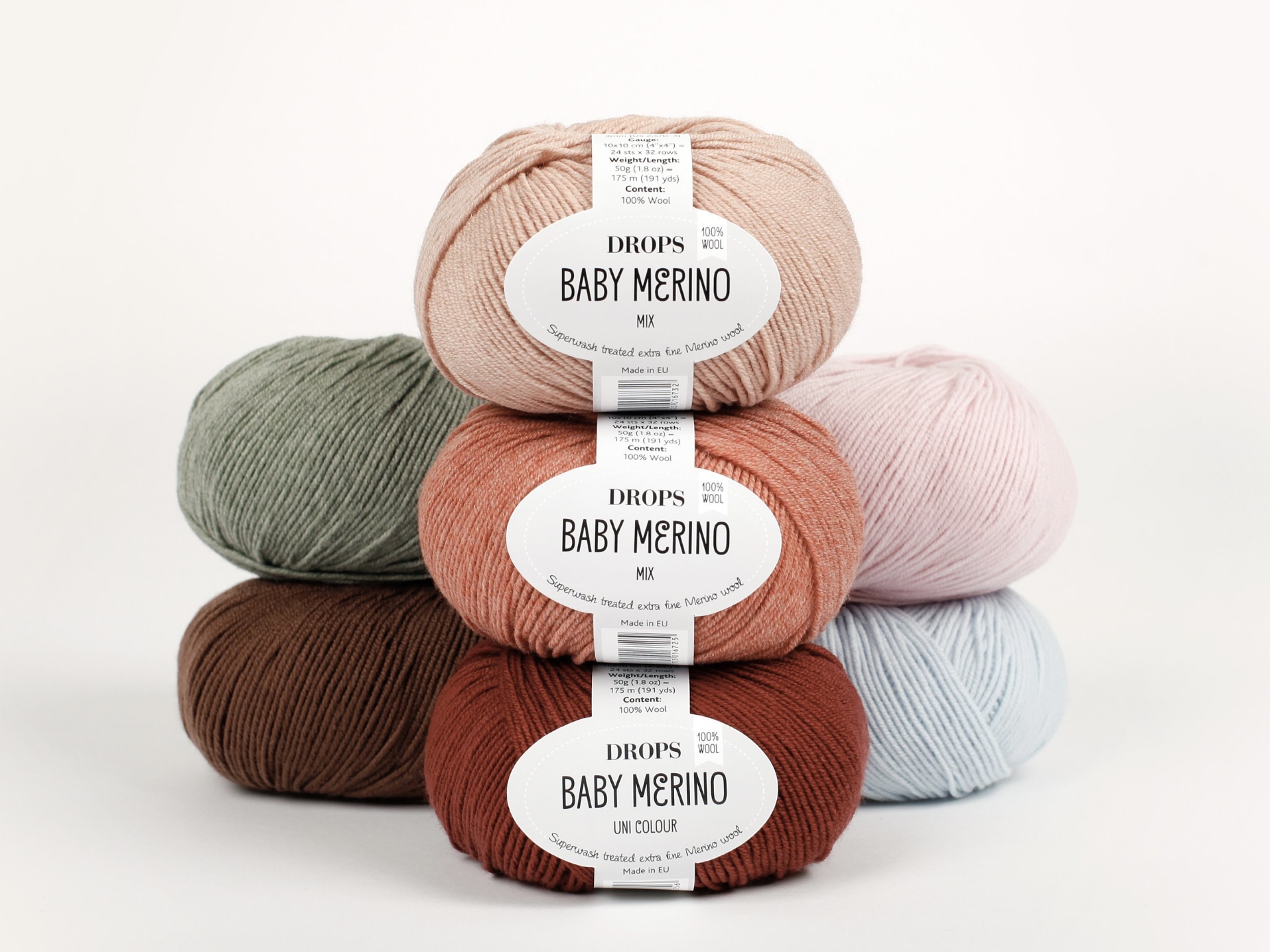 Drops Baby Merino yarn balls stacked in soft pastels