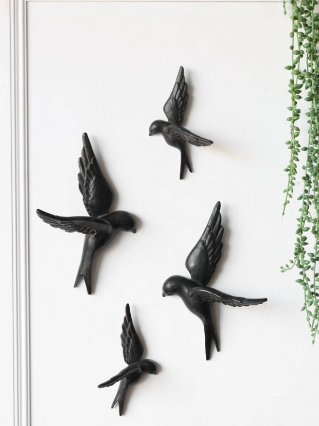 Set of black swallow wall ornaments flying above a console