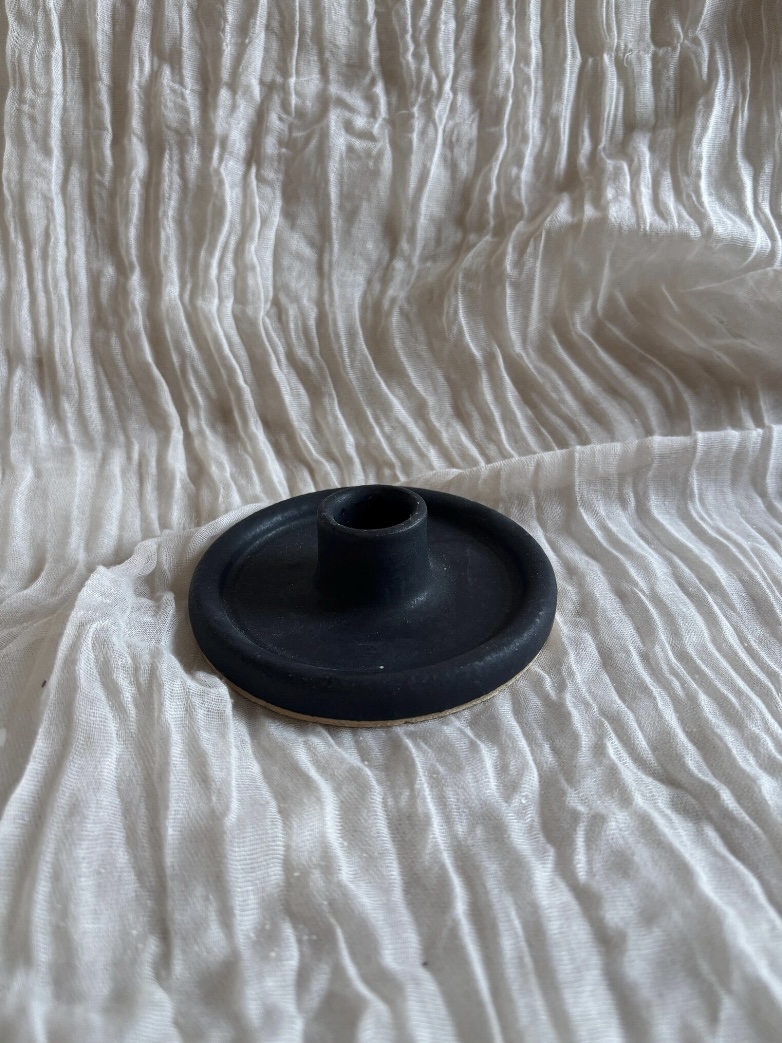 Minimal matte black candlestick holder on a modern black console table