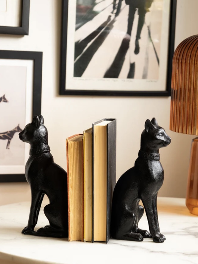Pair of black sitting cat bookends styling design books on a console