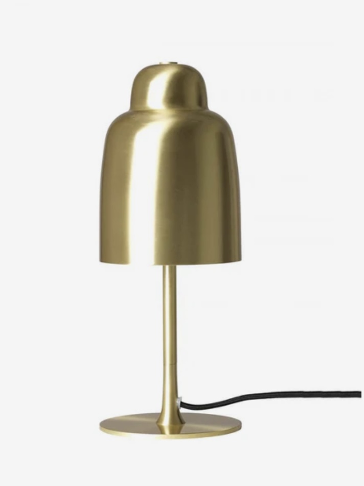 Brass table lamp with rounded shade on a console