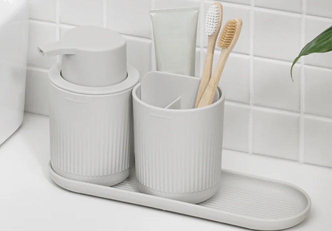 ReBorn bathroom set with recycled plastic soap dispenser, tumbler, and tray in light grey