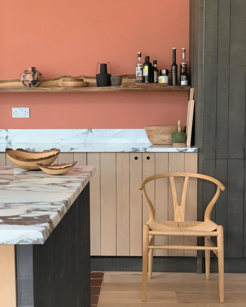 Feng shui kitchen colour with a terracotta wall, timber shelf and marble worktop
