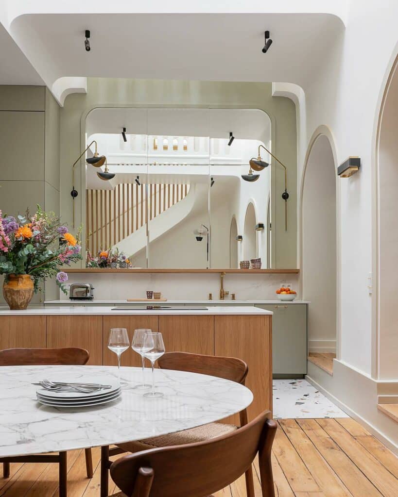 Two tone kitchen with Farrow & Ball French Gray cabinetry, natural oak island, Wimborne White walls and architectural arches with marble dining table.​​​​​​​​​​​​​​​​
