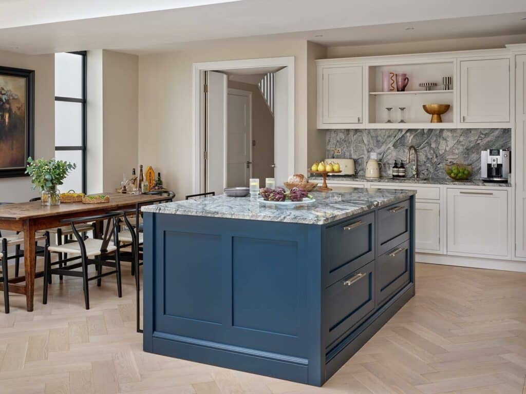 Two tone kitchen with Farrow & Ball Hague Blue island, Strong White shaker perimeter cabinets, veined marble worktop and herringbone oak flooring.​​​​​​​​​​​​​​​​