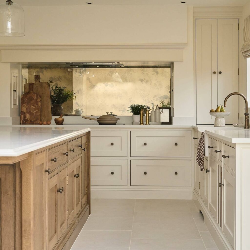 Two tone kitchen with Farrow & Ball Pointing painted perimeter cabinets, natural oak island, aged mirror splashback and antique brass hardware.​​​​​​​​​​​​​​​​
