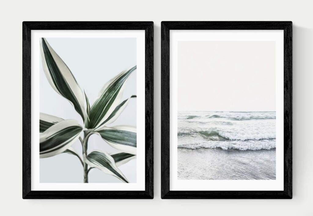 Botanical leaf print and grey seascape print in black frames as a pair