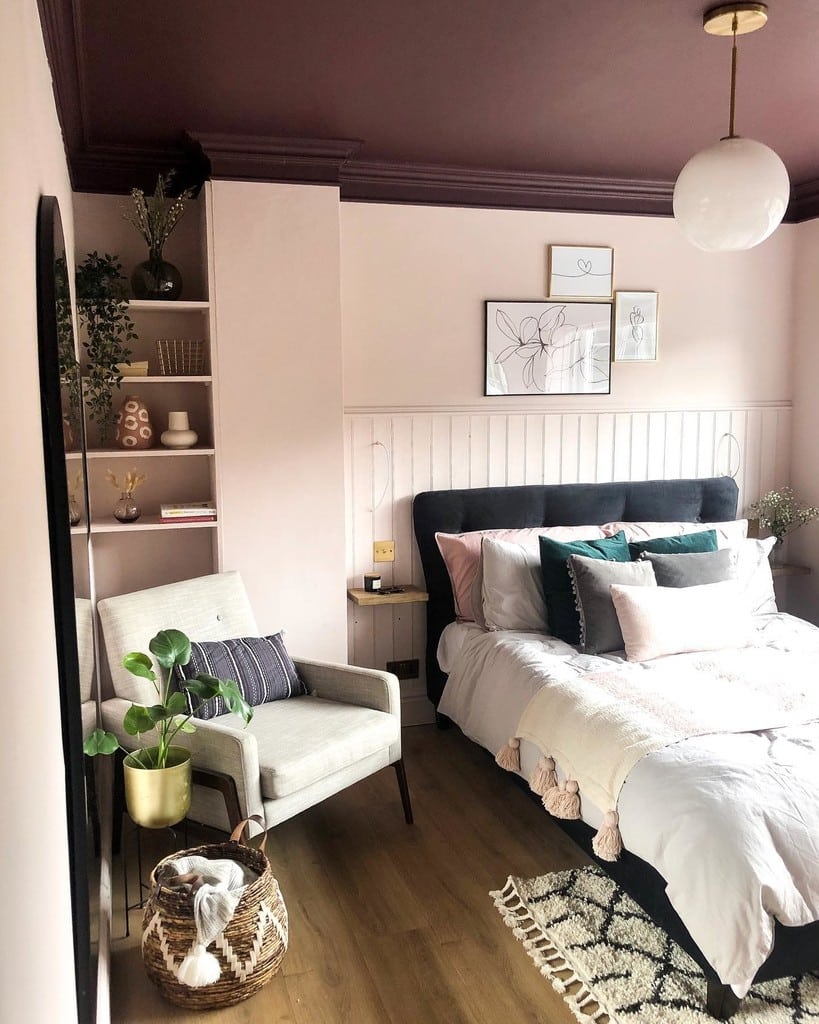 Cluster of line drawing prints above white panelling in a pink Calamine bedroom