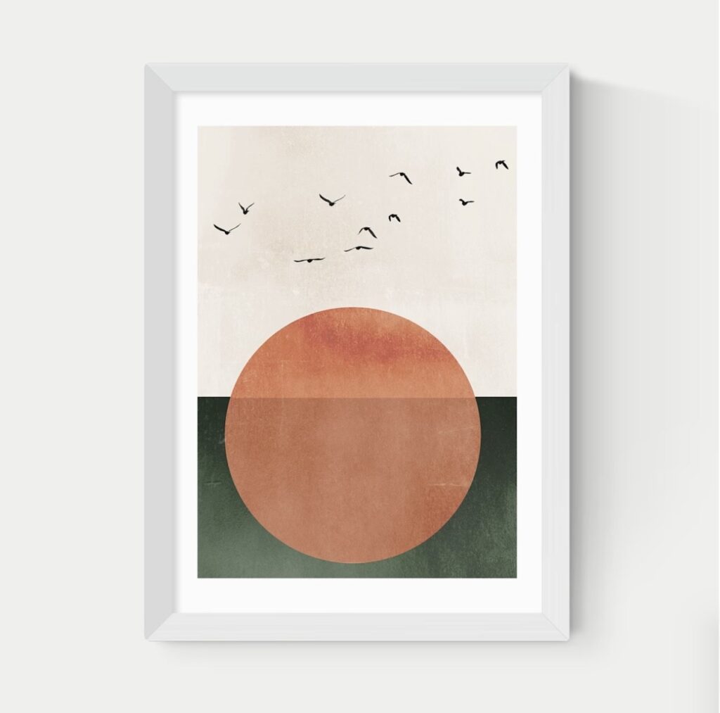 Modern abstract print of a terracotta sun over dark green in a white frame