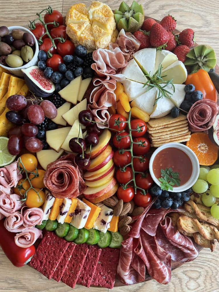 Cheese platter ideas board with brie, charcuterie, figs, cherries and crackers