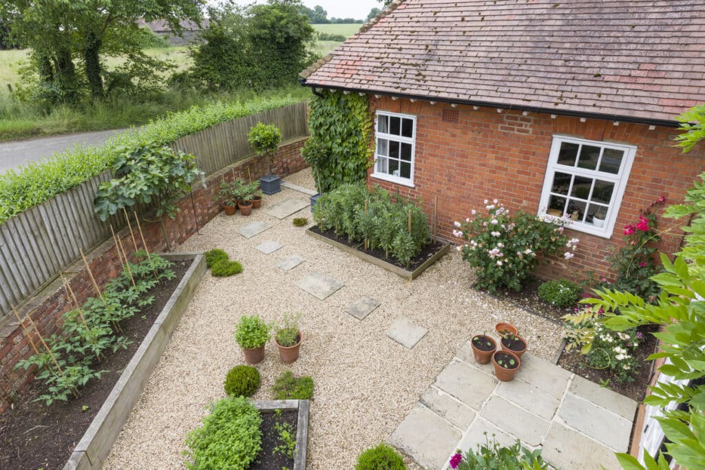 Low maintenance UK garden with gravel patio, raised beds and paving stones