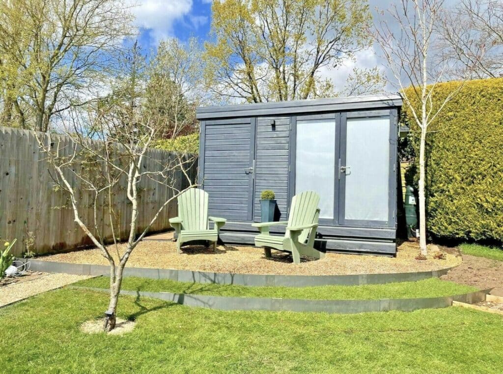 Corten steel edging defining a curved gravel border in a low maintenance modern garden design.