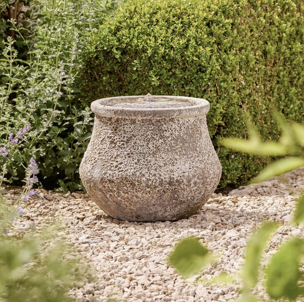 Stone-effect water feature in a gravel border – a calm focal point for low maintenance garden designs