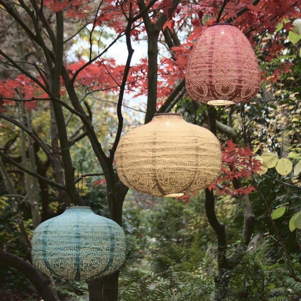 boho garden lanterns styled in trees for wooden pallet garden furniture