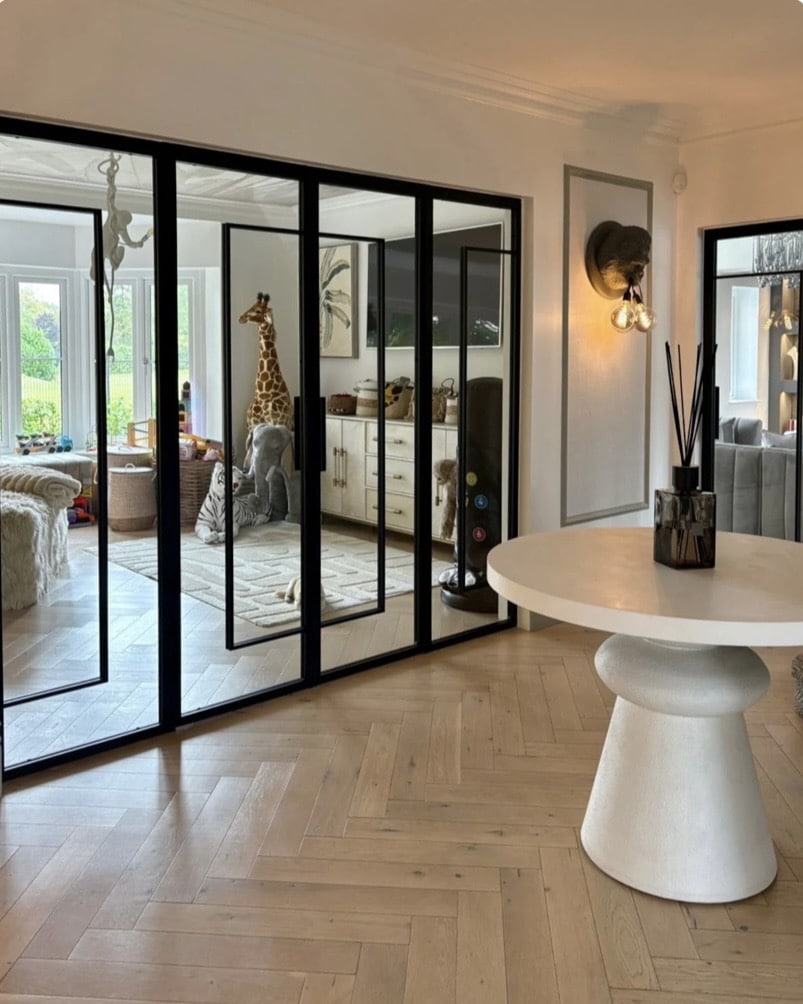 Glass partition room divider ideas: made to measure internal steel doors with ultra slim black frame dividing hallway from playroom in a British home