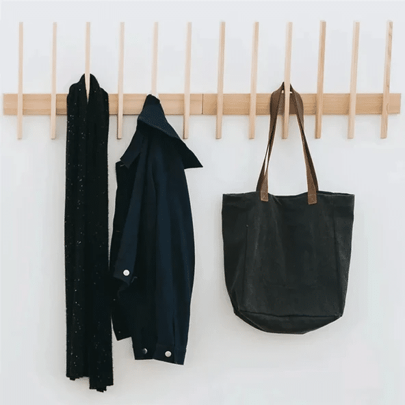 Black stained ash wall-mounted coat hook with scarf, jacket, and tote bag.