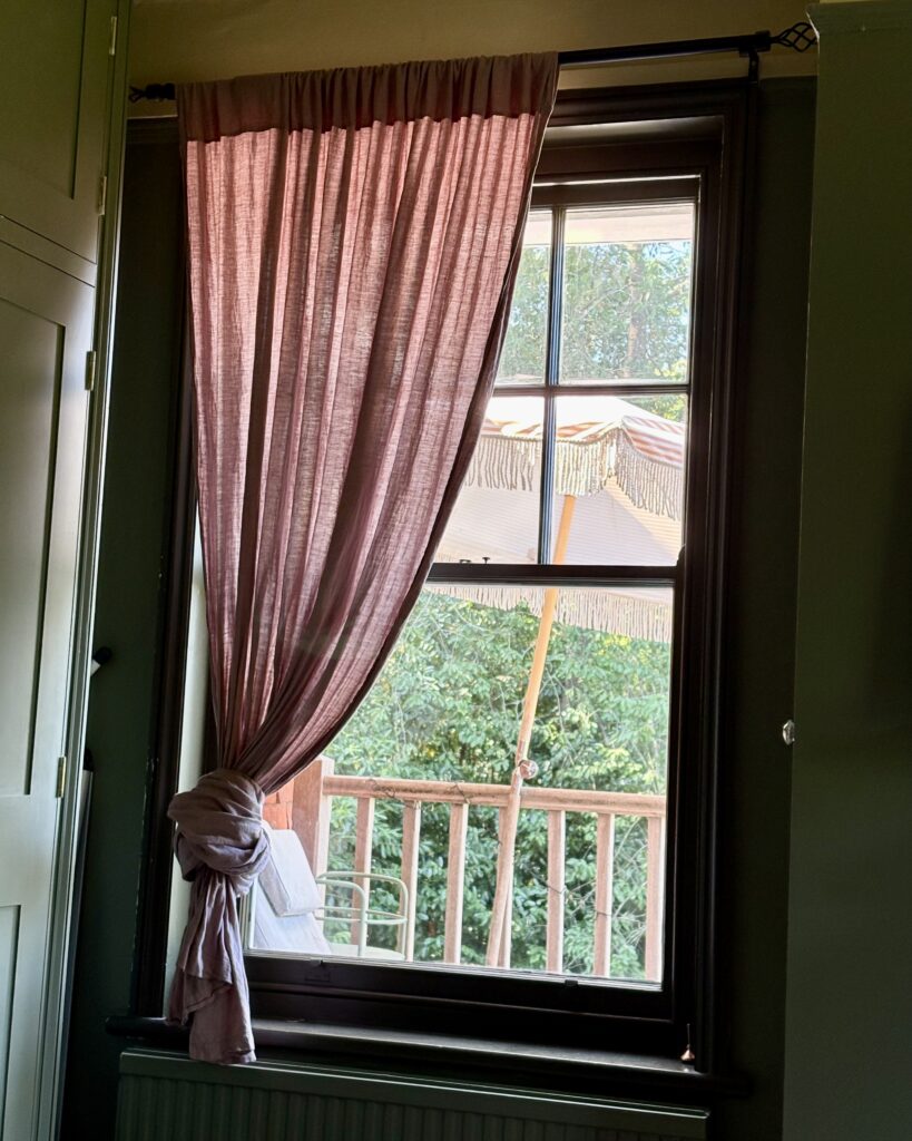 Small Bedroom Ideas: Maximise Space and Style in a Small Room Small bedroom ideas linen curtains Pink linen curtain tied back at small bedroom window.