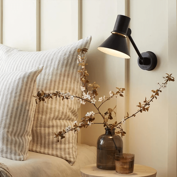 Anglepoise Type 80 wall light in matte black above a bedside table.
