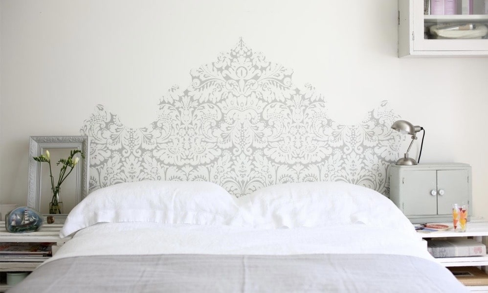Stencilled wallpaper headboard shape in a neutral small bedroom, Farrow & Ball.