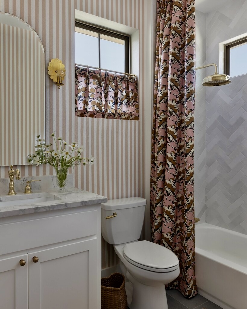 Small bathroom with Farrow & Ball Setting Plaster striped walls and a patterned pink and brown shower curtain