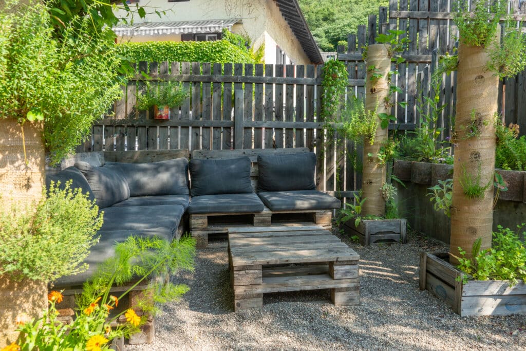 wooden pallet garden furniture: corner sofa in gravel garden small garden seating idea UK