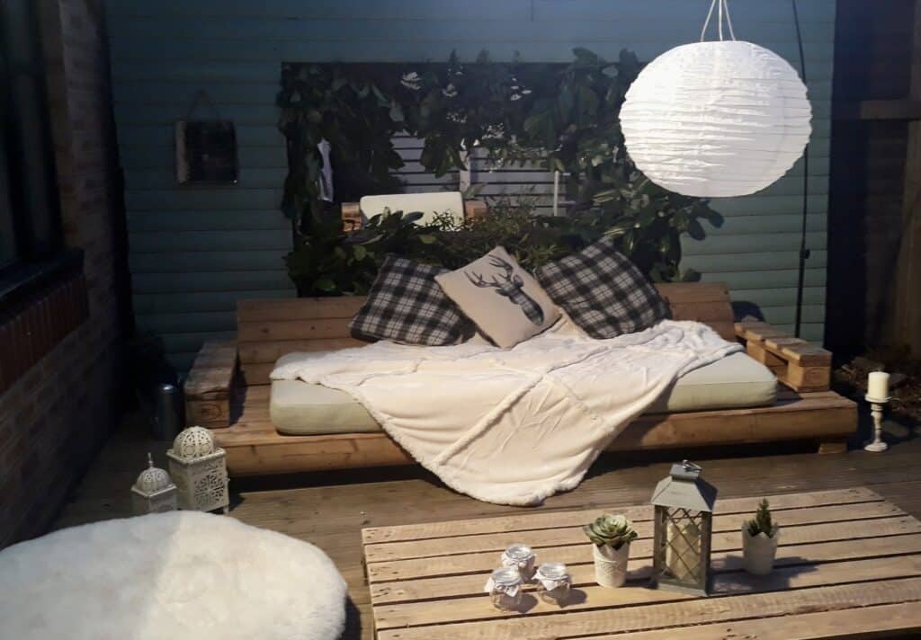 wooden pallet garden sofa with cushions cosy outdoor seating idea small garden UK