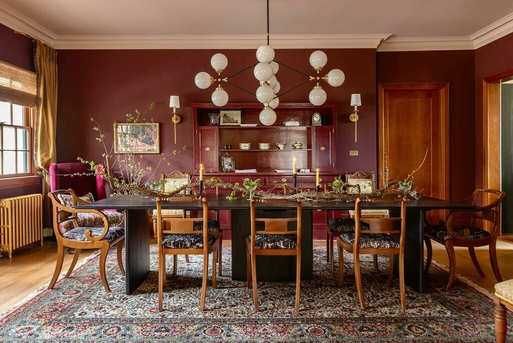 dramatic burgundy dining room with Farrow and Ball Preference Red walls, globe chandelier and Persian rug