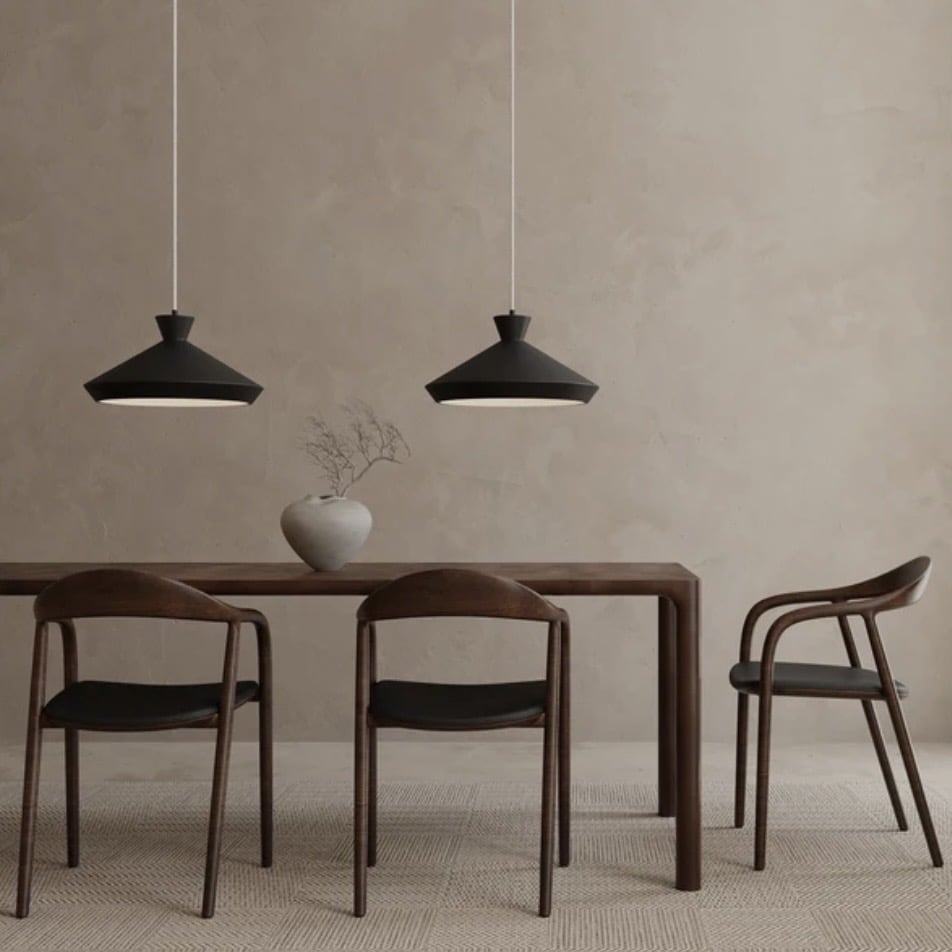Dining room lighting ideas featuring two modern black pendant lights suspended above a wooden dining table in a minimalist dining room