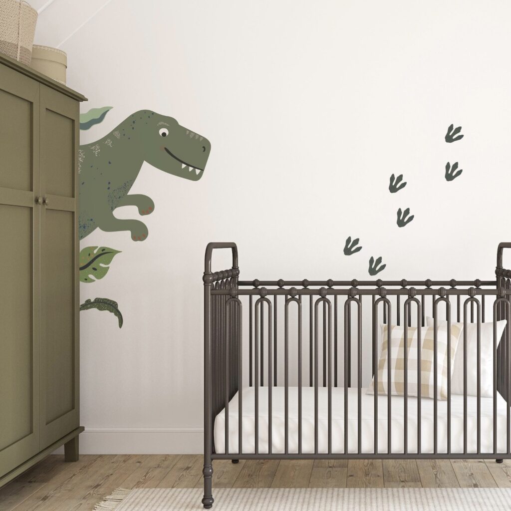 Baby boy nursery decor with T-Rex wall decal and iron cot