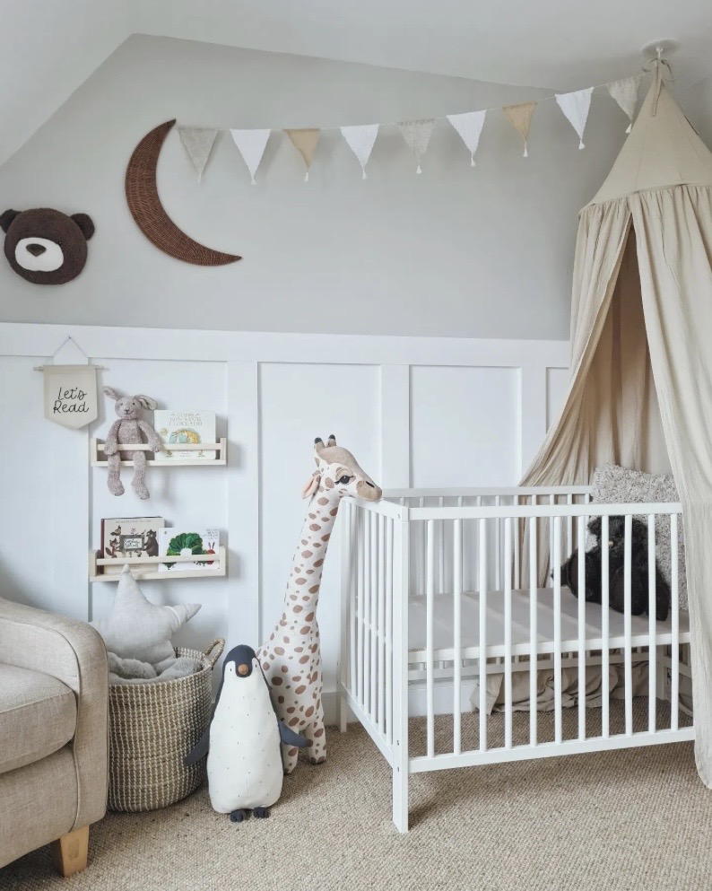 Nursery wall decor with fabric bunting and canopy above cot