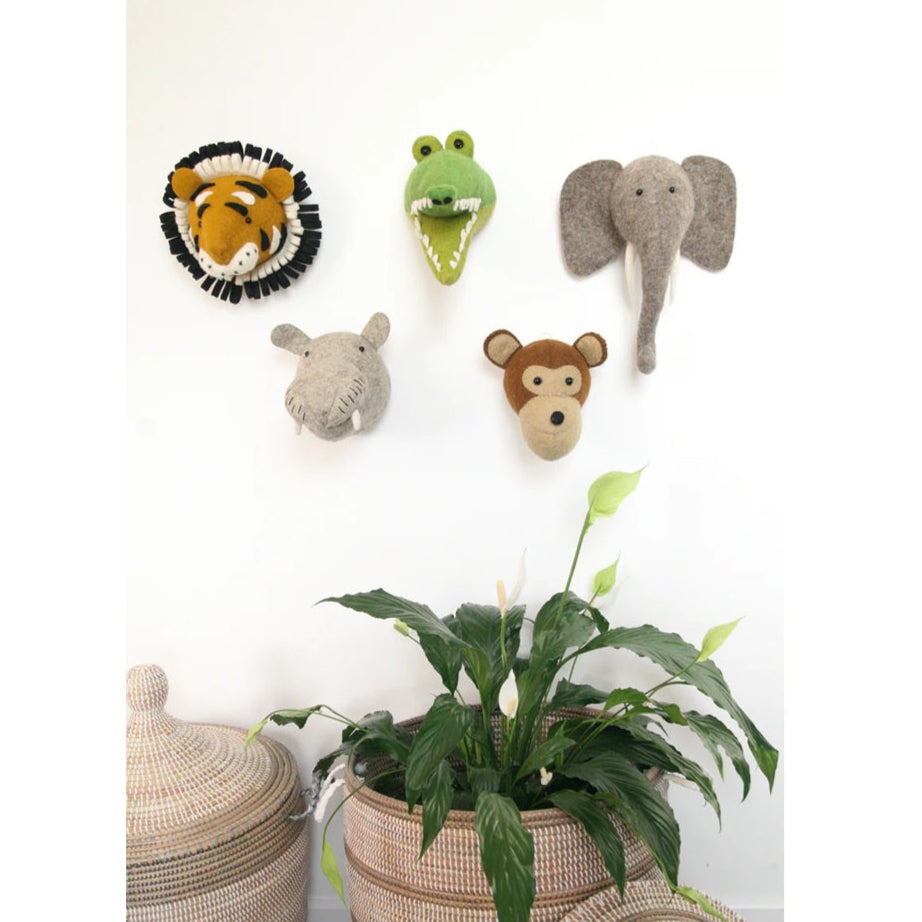 Safari nursery decor with felt animal wall heads and woven baskets