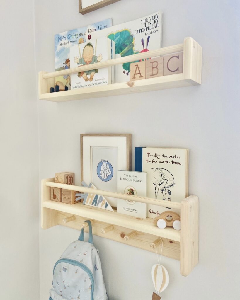 Wooden nursery bookshelf with peg rail for storage