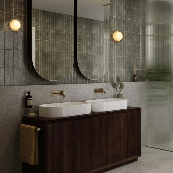 Twin Tala Firth wall lights either side of arched mirrors above a green tiled double vanity