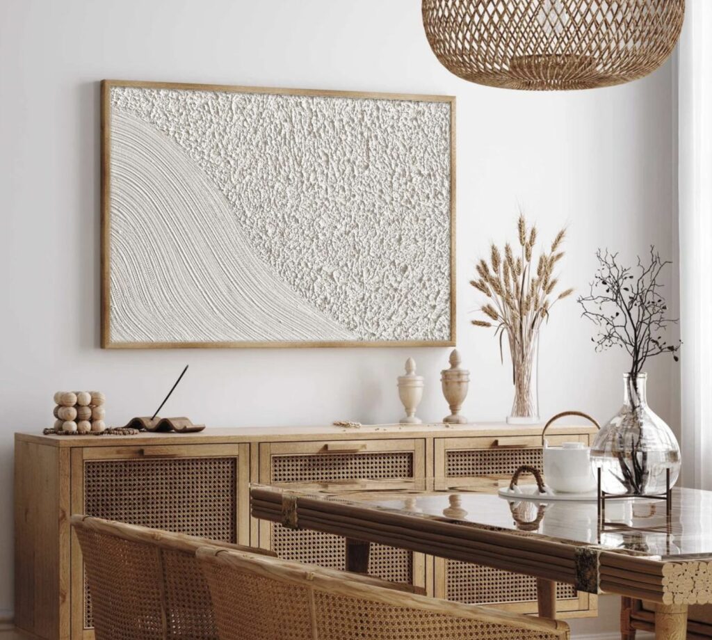 Wabi sabi interior design with 3D plaster wall art above cane and wood sideboard