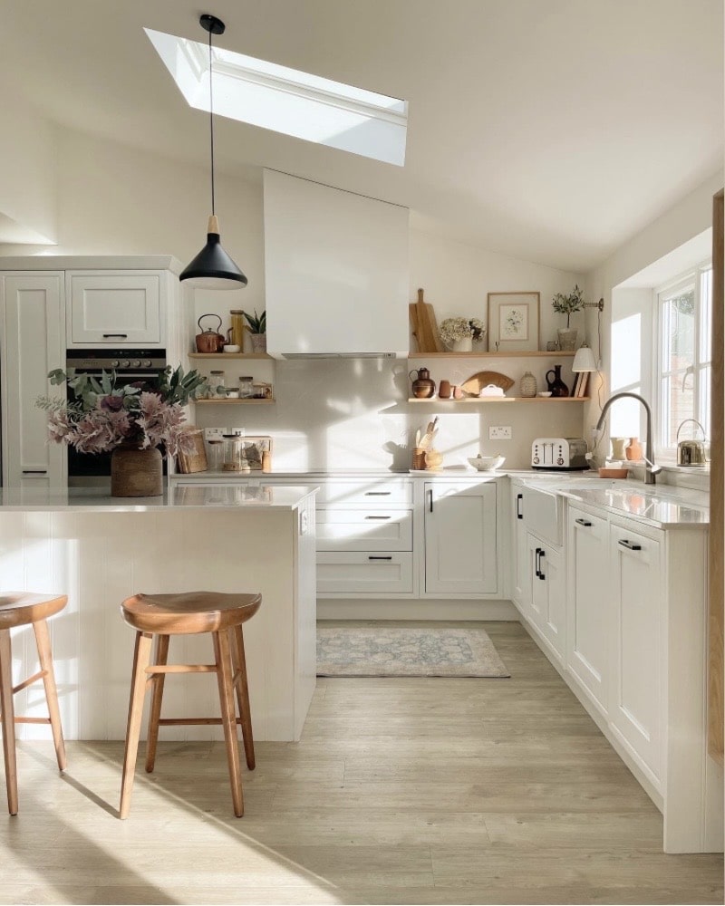 white scandi kitchen with wooden bar stools and skylight