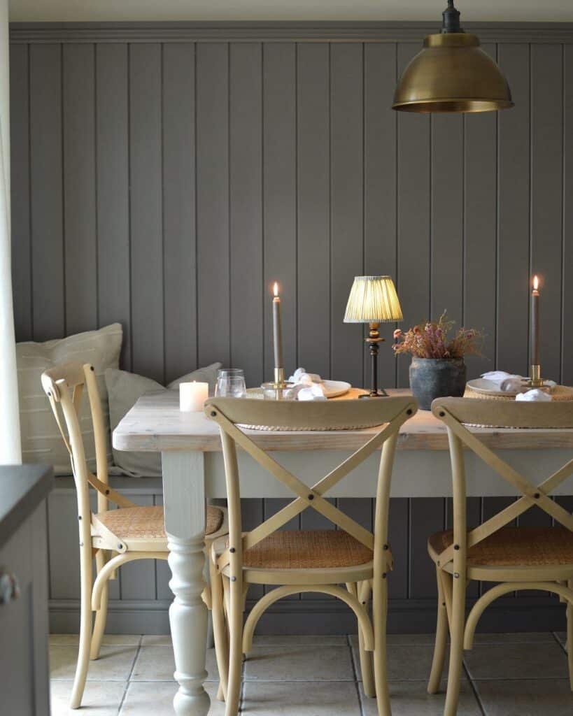 Dining room with floor-to-ceiling tongue and groove wall panelling in Farrow & Ball Mole’s Breath, brass pendant light and cross-back chairs.