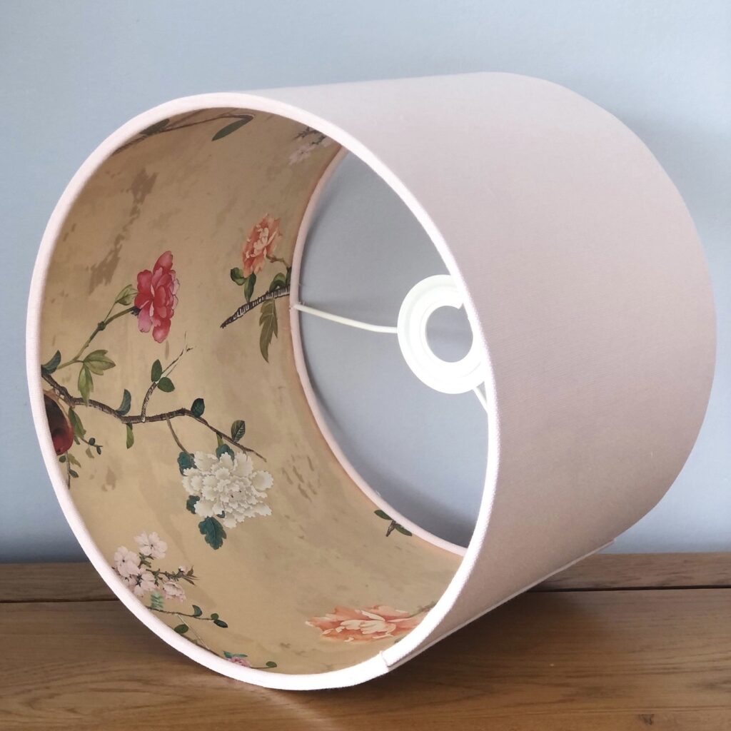Pale pink lampshade with gold chinoiserie bird lining, showing the patterned interior