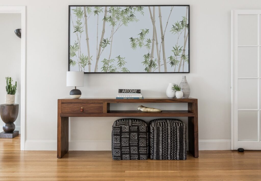 Bamboo print wall art above a wooden console in a chinoiserie-inspired living room