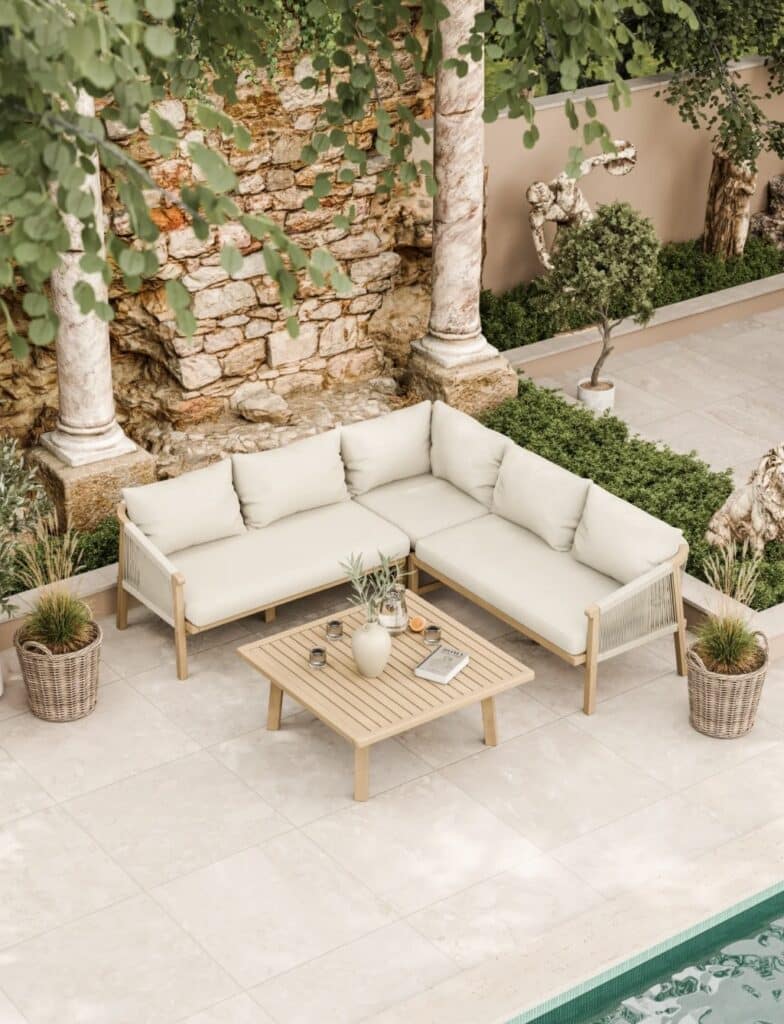 Neutral garden corner sofa set with 90 cm square coffee table and tall planters on pale stone patio.