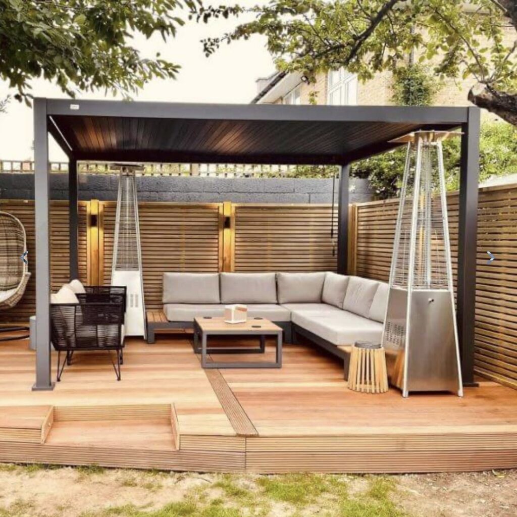 Corner garden sofa beneath a modern pergola on a raised deck creating a sheltered outdoor lounge