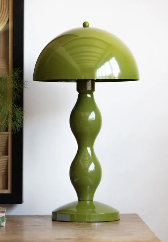 Green retro bedside lamp giving 70s vibe to a modern green and beige bedroom