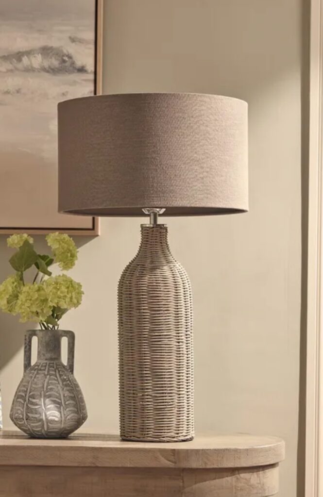 Beige rattan table lamp, giving a rustic feel to a green and beige bedroom