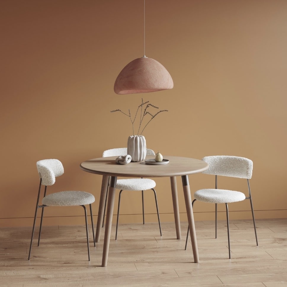 Affordable round oak dining table in pale white oak with tapered legs and upholstered dining chairs in a soft Scandinavian-style dining space