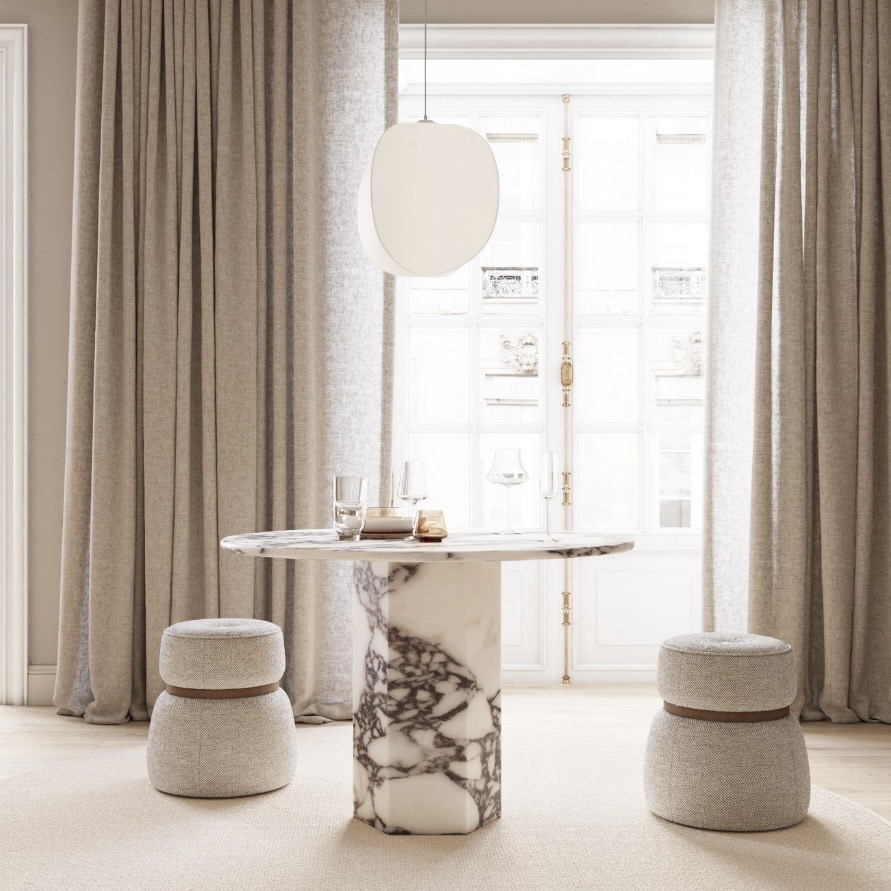 Round marble dining table with bold veined pedestal base and neutral upholstered stools in an elegant dining room