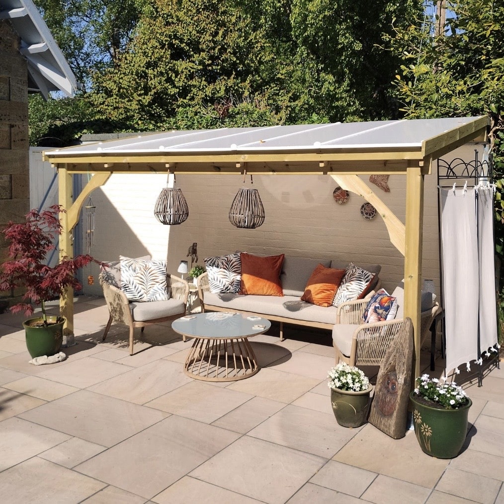 Wooden lean-to pergola shelter with polycarbonate roof over garden seating area