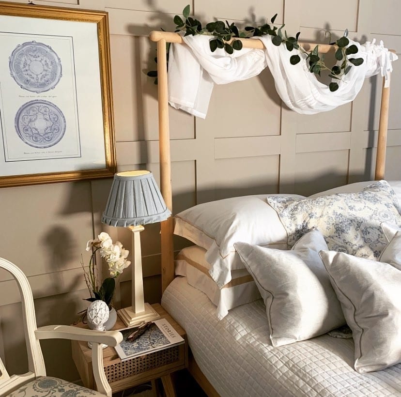 Beige and blue bedroom with Elephant’s Breath panelled walls, blue toile bedding and a canopy bed frame