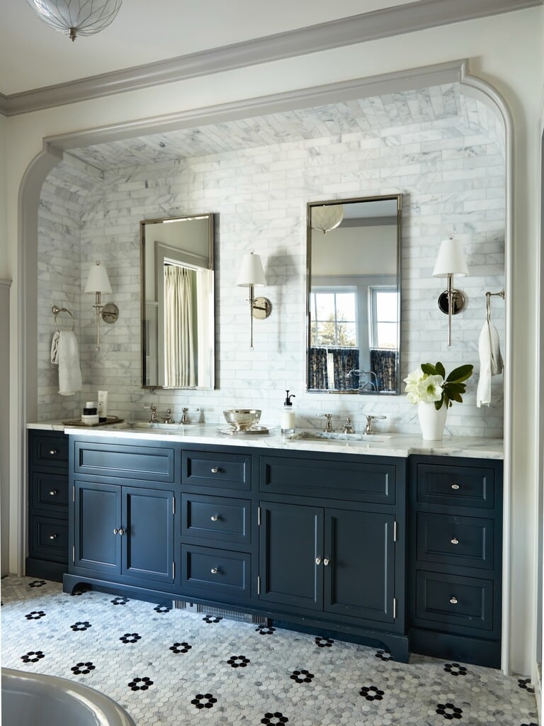 Black and white bathroom with navy Farrow & Ball Railings vanity, marble tiled splashback and floral mosaic floor