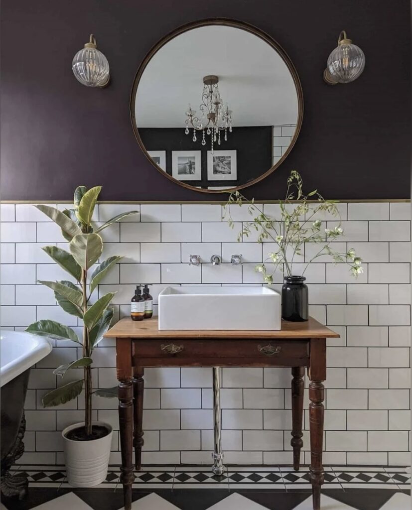 Black and white bathroom with Paean Black walls, subway tiles, wooden vanity, and farmhouse-style sink